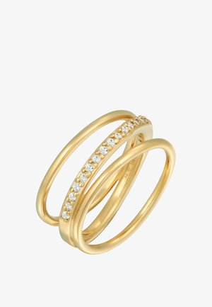 Guldtonet multi-band ring med et glat, buet design, prydet med klare krystaller langs en af ringbåndene, hvilket fremhæver elegancen og glansen.
