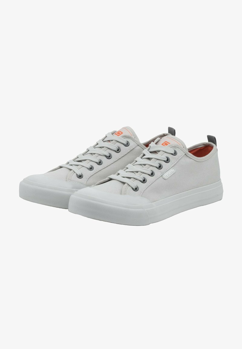 Lichtgrijze canvas sneakers met witte rubberen zolen, platte veters en een oranje logo-accent. De schoenen hebben een laag model en een ronde neus.