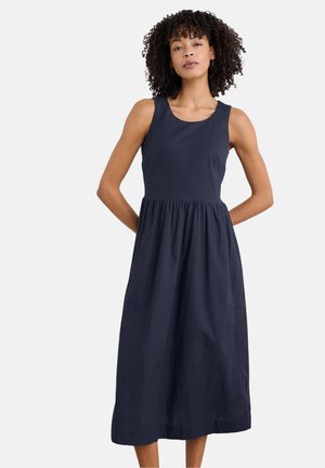 Navy-blue cotton sleeveless dress with a fitted bodice and gathered skirt, reaching mid-calf. Simple design with no additional patterns or accents.