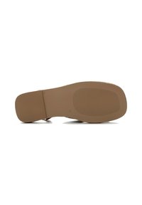 Tan rubber shoe sole with a textured surface and slight ridges for traction. Features a rounded shape and flat heel. No decorative elements.