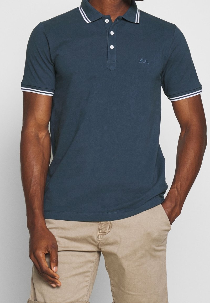 Námořnické polo tričko s dvoubuttonovým límečkem, bílými pruhy na límci a rukávech a vyšitým logem na hrudi. Materiál z bavlněné směsi.