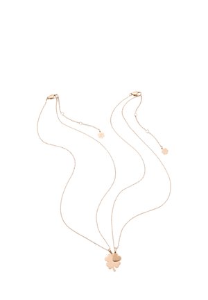 Two delicate gold chain necklaces with pendants, one shaped like a four-leaf clover and the other a heart, on a white background.