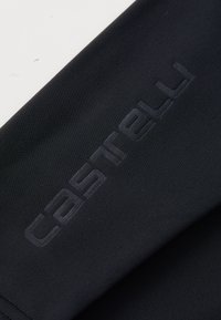 Schwarzer Stoff mit glatter Textur, auf dem der eingeprägte Markenname "castelli" in einer dunkleren Nuance diagonal über den Stoff positioniert ist.