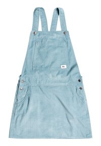 Světle modrá džínová šaty kombinéza s nastavitelnými popruhy, přední kapsou a bočními kapsami zajištěnými stříbrnými knoflíky. Měkká textura a ležérní design.