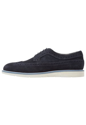 Mænds marineblå ruskind wingtip brogue sko med perforerede detaljer og hvid gummisål med blå kant.