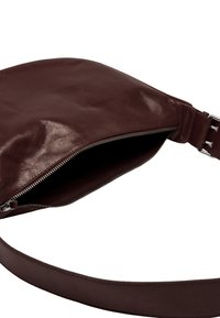 Brązowa skórzana torba o gładkiej fakturze, z zamkiem błyskawicznym i szerokim, płaskim kształtem. Zawiera mocny, regulowany pasek.