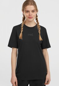 Black cotton t-shirt featuring short sleeves, round neckline, and a subtle embroidered logo on the chest. Smooth texture, relaxed fit.
