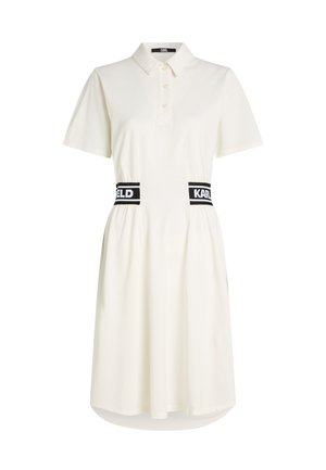 Weißes Polokleid mit kurzen Ärmeln, Kragen, geknöpfter Blende und schwarzem elastischem Bund mit den Schriftzügen „KARL“ und „FELD“.