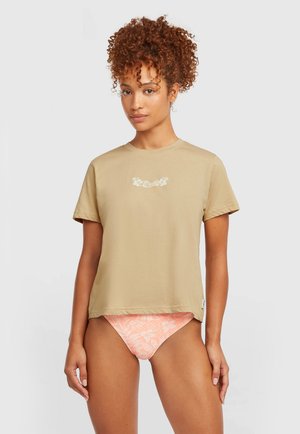 Beige katoenen T-shirt met korte mouwen en een ronde hals, met een witte bloemprint op de borst. Gecombineerd met roze bikini broekje met patroon.