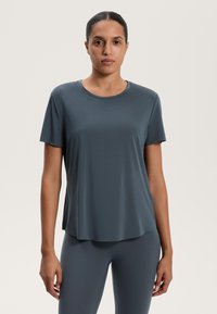 Sötét szürke, rövid ujjú póló sima, lélegző anyagból, kerek nyakkivágással és laza sziluettel. Finom szellőző részletek találhatók rajta.