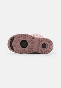 Rosa Gummisohle mit strukturiertem Muster aus Schneeflocken- und hexagonalen Formen; beinhaltet einen schwarzen Gummi-Akzent.