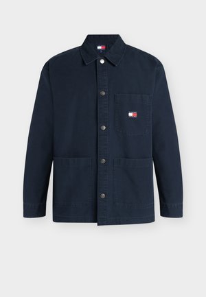 Tengerészkék, gombos dzseki három első zsebbel, gallérral és egy kis Tommy Jeans logóval a bal felső zsebén.