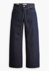 Jean denim bleu foncé à jambes larges avec poches avant, passants de ceinture, fermeture par bouton, braguette zippée et ceinture en tissu nouée à la taille.