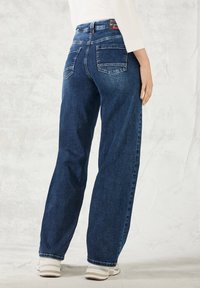 Breda jeans i mörkblå denim med hög midja, två bakfickor och subtila blekningsdetaljer.