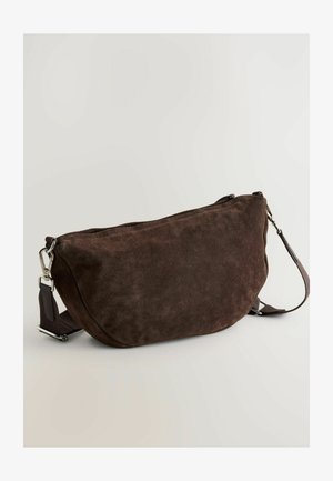 Brūns zamšs crossbody soma ar izliekto formu, ar rāvējslēdzēju augšpusē un regulējamu siksnu. Aprīkota ar sudraba toņu metāla detaļām un maigu tekstūru.