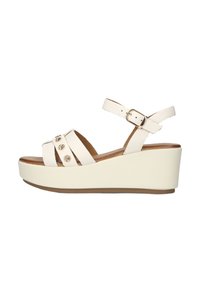 Witte wig sandalen met kruisbanden en goudkleurige accenten. Het ontwerp heeft een ronde neus, een verstelbare enkelband en een gestructureerde zool.