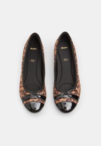 Pantofle baletowe w leopardzi wzór z czubkiem z czarnej lakierowanej skóry i detalem w postaci kokardki. Tkaninowe wierzchy z gładką czarną podszewką i wyściełaną wkładką.