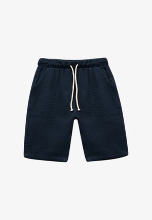 Pantaloni corti blu navy con cintura elastica, chiusura con cordoncino e due tasche laterali. Tessuto texturizzato con sottili linee orizzontali.