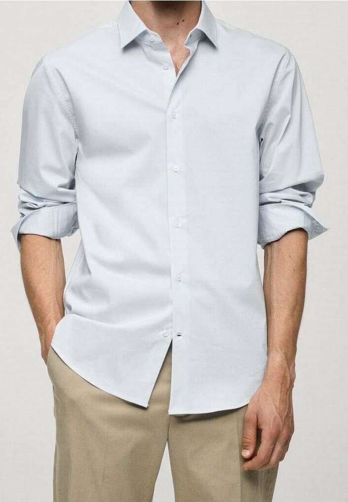 Camisa de manga larga azul claro de algodón, con cuello clásico, mangas largas remangadas hasta los codos y dobladillo recto.