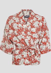 Red floral wrap top featuring white botanical patterns, short sleeves, a tie belt at the waist, and a V-neck design. Cotton blend material.