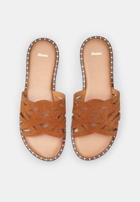 Sandali in suede marrone con un design a fascia intrecciata, soletta interna liscia e un bordo marrone borchiato. Logo "Bata" visibile sulla soletta.