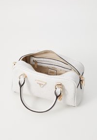 Borsa bianca testurizzata con accessori in oro, accenti neri e doppi manici superiori. La cerniera aperta rivela un interno beige con diversi scomparti.