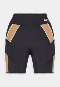 Shorts de sport moulants noirs et marron clair avec une taille haute et un liseré blanc, avec le logo BOSS sur la taille.