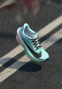 Sneaker Nike Zoom Fly con tomaia blu chiaro, accenti neri, dettagli verdi e suola rosa, con unDesign in mesh texturizzato.