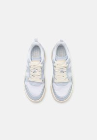 Zapatillas deportivas en azul claro y blanco con paneles de malla, cordones color crema y una suela acolchada, con un patrón texturizado en la plantilla.