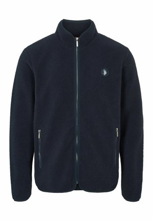 Giacca in pile blu navy con colletto alto, zip frontale, due tasche laterali e un logo circolare sul petto. Materiale testurizzato e morbido.