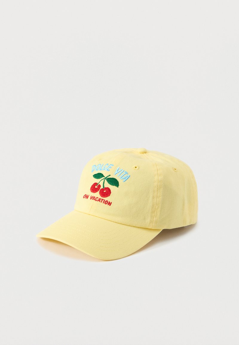 Casquette de baseball jaune avec des cerises brodées et le texte "DOLCE VITA ON VACATION" en fil bleu et rouge.