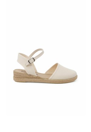 Canvas espadrille sandaal in beige met een geweven jute tussenzool. Beschikt over een enkelband met een metalen gesp en een gesloten teenontwerp.