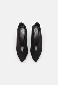 Scarpe con tacco alto in suede nero, con punta affusolata e design a taglio a V. L'interno presenta una finitura liscia con la taglia contrassegnata come 37.