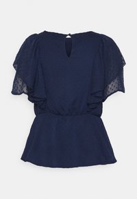 Haut bleu marine avec des manches courtes et flottantes, en tissu à pois texturé, taille élastique et petite ouverture en forme de clé dans le dos.