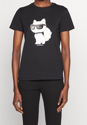 Musta puuvillainen t-paita, jossa on sarjakuvatyylinen aurinkolaseja käyttävä kissa, pyöreä kaula-aukko ja lyhyet hihat. Valkoinen graafinen yksityiskohta edessä.
