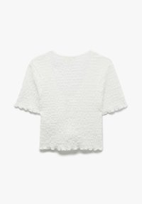 Vit kortärmad texturerad stickad topp med scalloperade kanter på ärmarna och fållen, med en något croppad och figurnära silhuett.