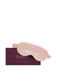 Masque de sommeil en soie rose douce reposant sur une boîte violet foncé avec un texte doré indiquant masque de sommeil en soie de luxe.