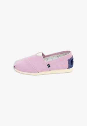Zapatilla de lona rosa claro tipo slip-on con suela color crema y parche azul en el talón, mostrada de perfil sobre fondo blanco.