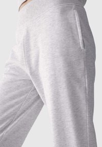 Graue Sweatpants aus weichem Stoff, mit einem elastischen Bund, Seitentaschen und einem dezenten Logo in strukturiertem Finish.