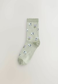 Gestreepte groene sok met een gerimpelde boord. Heeft motieven van schapen en lavendel in zwart en paars. Gemaakt van zachte stof.