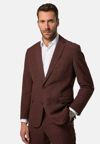 Completo maroon con una finitura texture, taglio slim, design monopetto, revers a lancia, due tasche frontali e una camicia bianca sotto.