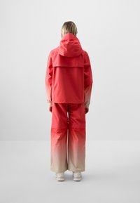 Red gradient waterproof jacket and trousers, featuring a hood, wide-leg design, and smooth texture, transitioning to light beige at the bottom.