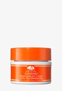 Crème éclaircissante pour les yeux dans un pot circulaire blanc avec un couvercle orange. Présente une étiquette avec le nom du produit et les détails de volume en texte blanc.