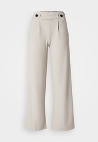 Beige vida byxor med en texturerad tyg, med en rynkad midja och två svarta knappar fram för stängning.