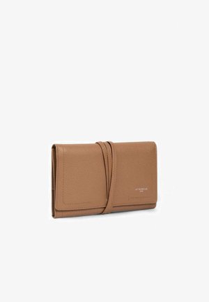 Portefeuille en cuir fauve avec fermeture à sangle enveloppante et texte de la marque "Le Tanneur" discrètement embossé sur le rabat avant.