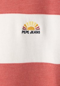 Svītrainā T-kreklā ir sarkanas, baltas un gaiši dzeltenas krāsas. Iekļauts izšūts "Pepe Jeans" logotips ar saules dizainu. Mīksta tekstūra.