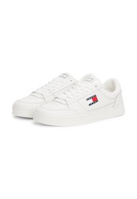 Baskets en cuir blanc avec un design à tige basse, un bout rond, un système de laçage sur le devant et un logo avec des accents rouges et bleus sur le côté.