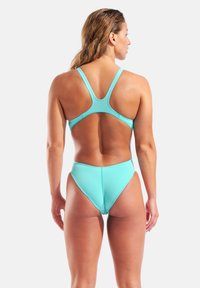 Turkoosi bikinit, joissa on racerback-malli. Sisältää sileän, joustavan kankaan, korkeavyötäröisen alaosan ja minimalistisen leikkauksen virtaviivaiseen istuvuuteen.