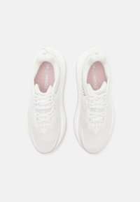 Baskets blanches avec un dessus en maille texturée, une languette rembourrée et des lacets. Présentent une semelle intérieure rose clair et un branding subtil sur le côté.