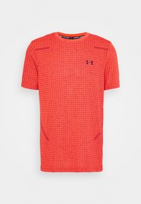 Camiseta atlética roja con un patrón de cuadrícula, mangas cortas, cuello redondo y logo de Under Armour en azul marino en el lado izquierdo del pecho.